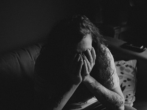 Black and white photo of hands covering a person's face