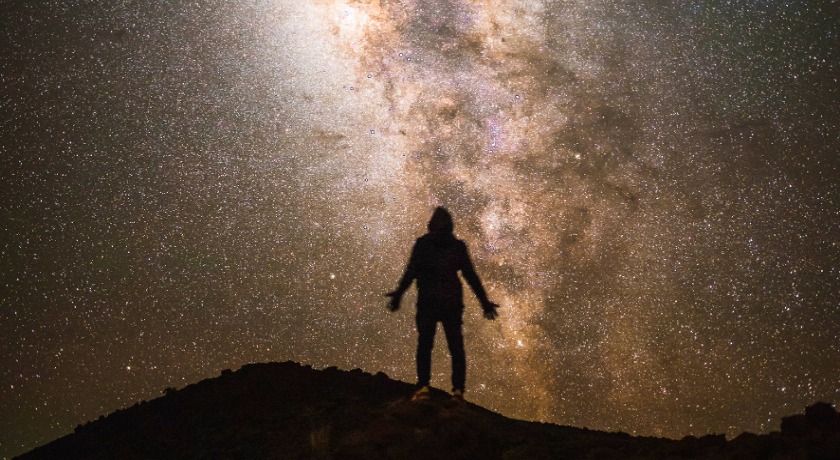 Person staring at starry sky news banner