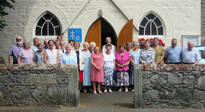 Members of Guernsey United Reformed Church standing outside the church building