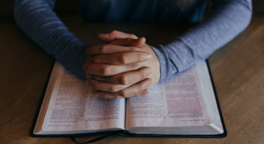 praying hands on bible